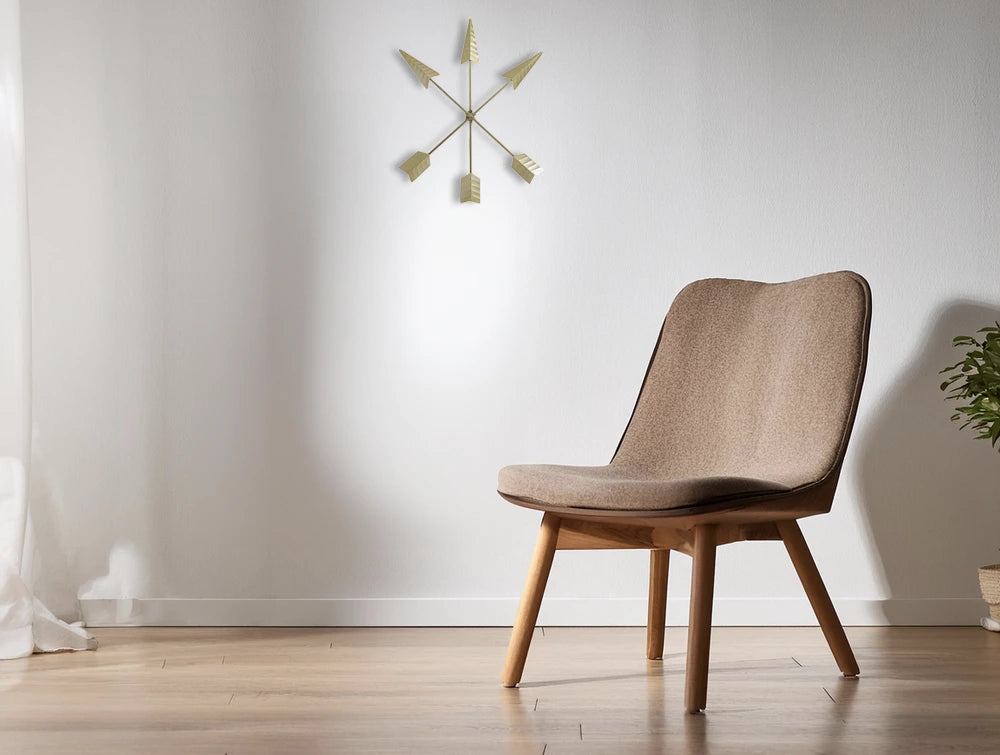 Metalen ster wanddecoratie met pijlen boven een moderne stoel in een lichte woonkamer